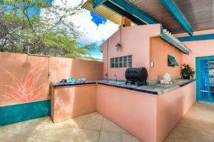 an outdoor kitchen in a home with a pink wall at Beachfront Two-Bedroom Villa in Savaneta