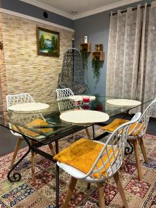 a dining room with a glass table and chairs at Maison de vacances campagnes in La Celle-Guénand