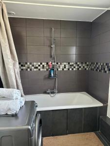 a bath tub in a bathroom with black and white tiles at Maison de vacances campagnes in La Celle-Guénand +38 photos