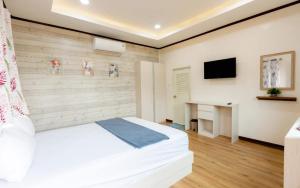 a bedroom with a large white bed and a desk at villa Tip in Ban Na An