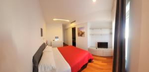 a bedroom with a red and white bed and a television at Appartamenti Ariston - Centro Giulianova in Giulianova