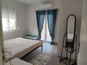 a bedroom with a bed and a mirror and a window at NMD house in Ermioni