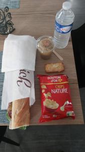 a sandwich and a bag of chips and a bottle of water at Chambre Magnolias in Saint-Sauveur-dʼÉmalleville +6 photos