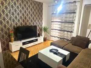 a living room with a couch and a tv at Centar Apartment in Kumanovo