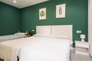 a bedroom with a white bed and a green wall at Casa Rural Viña Vella in Esteiro +56 photos