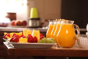 a tray with a plate of fruit and a pitcher of orange juice at Casa das Marés 3 in Baleal