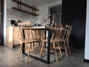 a dining room table with four chairs around it at Bukowy Zakątek in Brenna