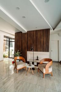 a living room with two chairs and a table at Hotel QC in Trujillo