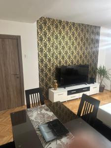 a living room with a dining table and a television at Centar Apartment in Kumanovo +5 photos
