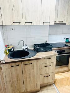 a kitchen counter with a sink and a stove at Centar Apartment in Kumanovo