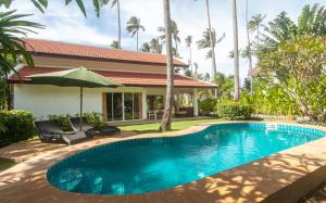 a swimming pool in the backyard of a house at Malee Beach F3 in Phra Ae beach