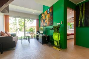 a living room with green walls and a vase on the wall at Malee Beach F3 in Phra Ae beach