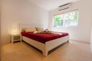 a bedroom with a bed with a red blanket and a window at Malee Beach F3 in Phra Ae beach