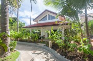 a house with a palm tree in front of it at Malee Beach F3 in Phra Ae beach