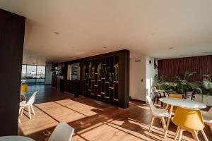 a room with a table and chairs and a wine cellar at Hotel QC in Trujillo