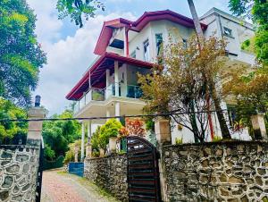 a house with a gate in front of a stone wall at Sampath Grand Hotel in Mawanella