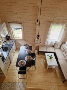 a kitchen and living room with a table and a couch at Vanagu priedes in Kalngale