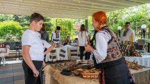 a man and a woman standing in front of a table with food at Pensiunea Eden in Târgu Neamț