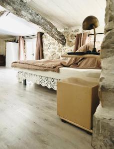 a bedroom with a bed in a stone wall at Aube du Tilleul in Lagorce