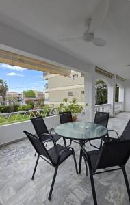 a patio with a glass table and chairs at Animus House #1 Apartment, Peraia in Perea
