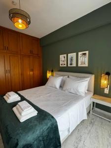 a bedroom with a large white bed with a green wall at Animus House #1 Apartment, Peraia in Perea