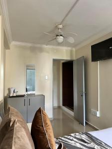a bedroom with a ceiling fan and a bed at Montrose BnB in Margate