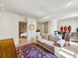 a living room with a couch and a clock on a wall at Rouge on Rose Boutique Hotel in Cape Town
