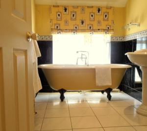 a bathroom with a tub and a sink at The Hunters Rest Inn in Clutton