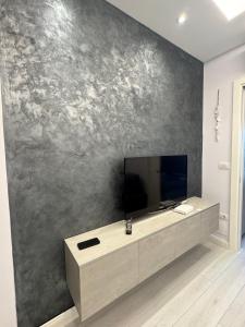 a living room with a television on a wall at Arli's SeaFront Apartaments in Durrës