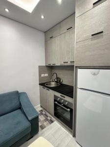 a small kitchen with a blue couch and a sink at Arli's SeaFront Apartaments in Durrës +13 photos