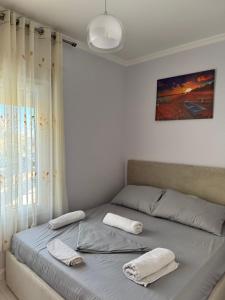a bedroom with a bed with two towels on it at Arli's SeaFront Apartaments in Durrës