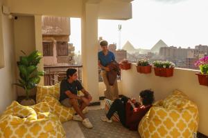 a group of people sitting on a balcony at Rafiki Hostels - Pyramids in Giza