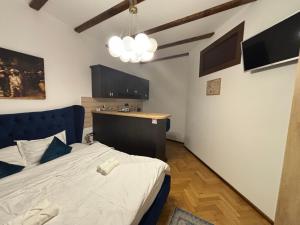 a bedroom with a blue bed and a kitchen at Kromatic 5 Boutique Studios - Old town Center in Braşov