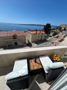 a balcony with two chairs and a table on a roof at Apartments Emilija in Brela