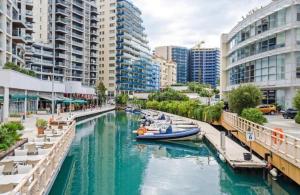 a river with boats in a city with buildings at Gibraltar Luxe Stay in Gibraltar