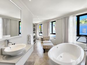 a white bathroom with a large tub and a sink at Rouge on Rose Boutique Hotel in Cape Town +79 photos