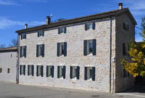 a large brick building with black windows at le chemin des pouzes in Vallon-Pont-dʼArc