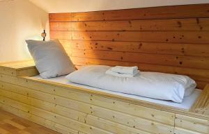 a bed in a room with a wooden wall at Ferienwohnung Steinbock mit Bergblick in Bayrischzell +8 photos