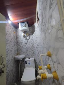 a bathroom with a toilet and a sink at Nishad Raj bhawan in Vrindāvan