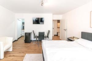 a white room with a bed and a table and chairs at Hotel Essen mit Apartments in Essen +123 photos