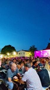 a large crowd of people sitting at tables at a concert at Hehlentor Fachwerkwohnung in Celle