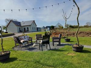 a group of chairs sitting in the grass at Sleeps6-FamilyFriendly-FreeParking-Garden in Ballybunion