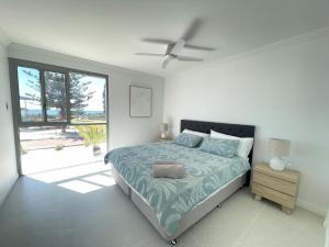 a bedroom with a bed and a ceiling fan at Coastal Calm Seascapes Halls Head in Falcon