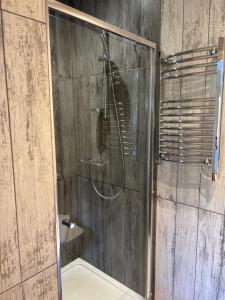 a shower with a glass door in a bathroom at The Church House in Torver