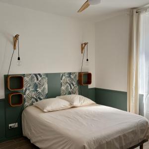 a bedroom with a bed with two lights above it at le chemin des pouzes in Vallon-Pont-dʼArc +105 photos
