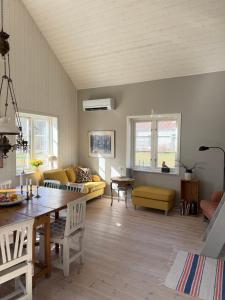 a living room with a table and a couch at Idyllically nice house on Bjärehalvön, Torekov! in Båstad +32 photos
