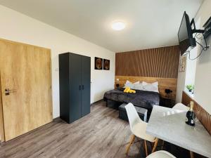 a bedroom with a bed and a table and chairs at Too Apartment Lipno in Černá v Pošumaví