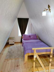 a bedroom with a purple bed in a attic at Metsadzor Resort, Areni in Areni