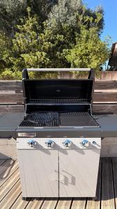 a barbecue grill sitting on a wooden bench at Villa Bella Vita in Biguglia