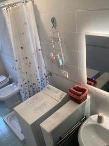 a bathroom with a sink and a toilet and a shower at Villa Colline Fiorite in Putignano